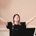 Young girl praying with arms raised